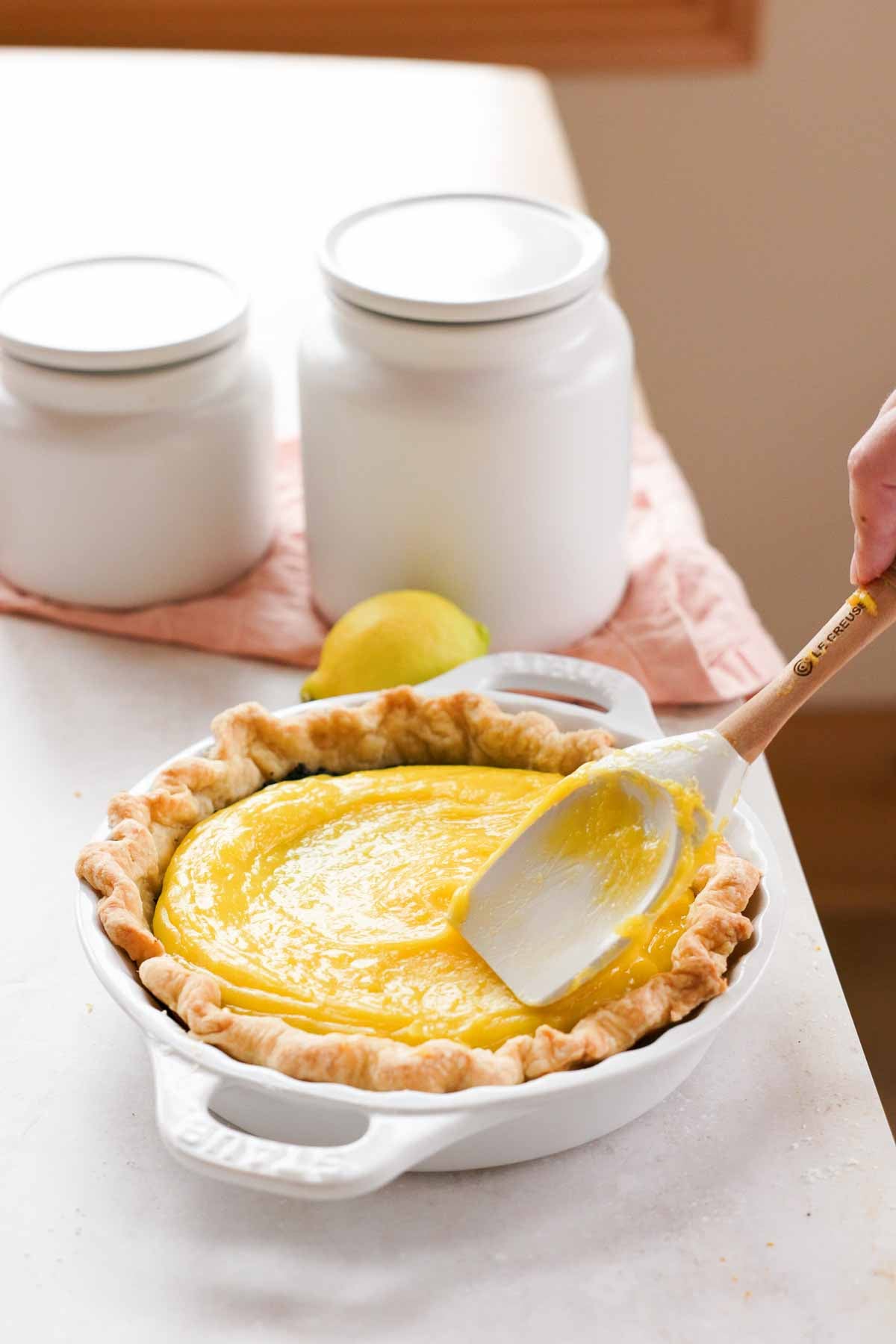 spreading lemon curd pie filling into pie crust