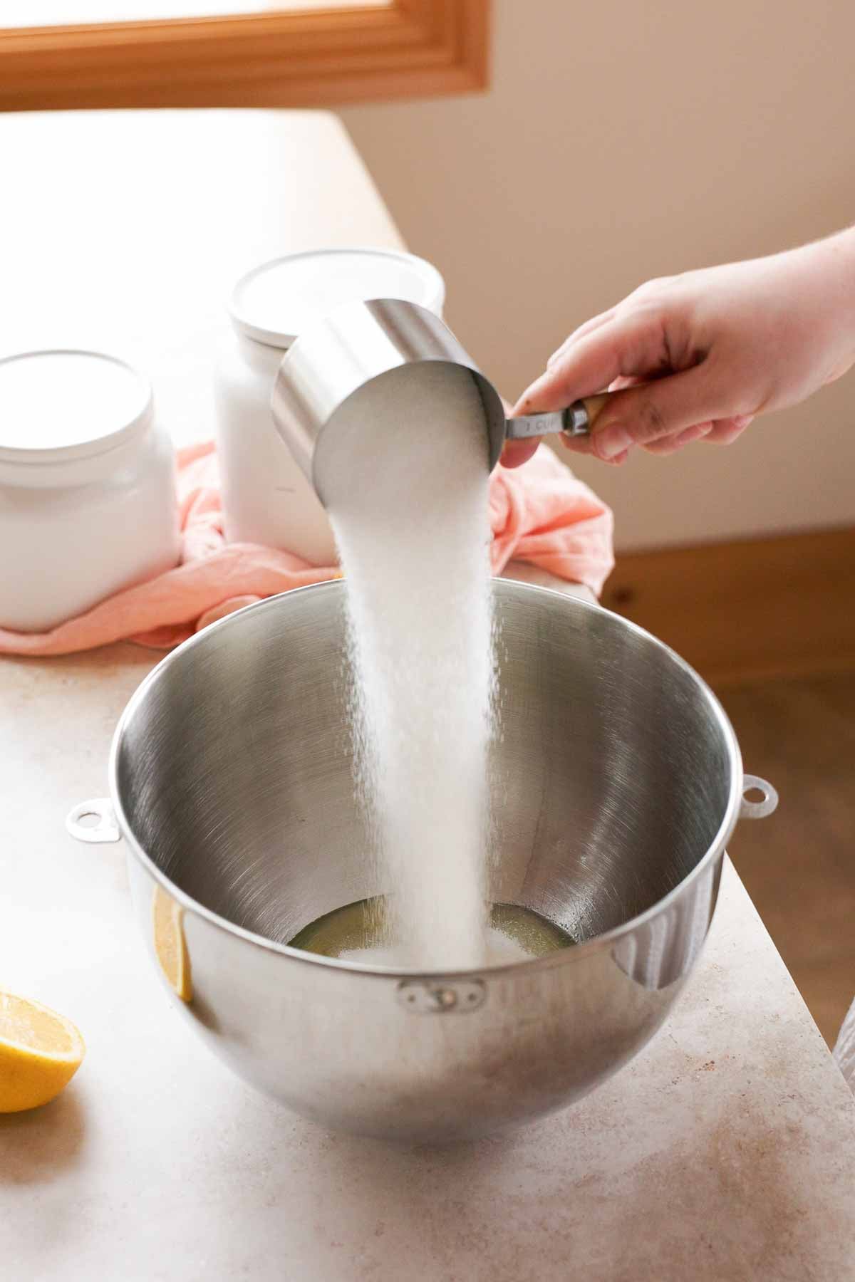 adding sugar into stand mixer with egg whites
