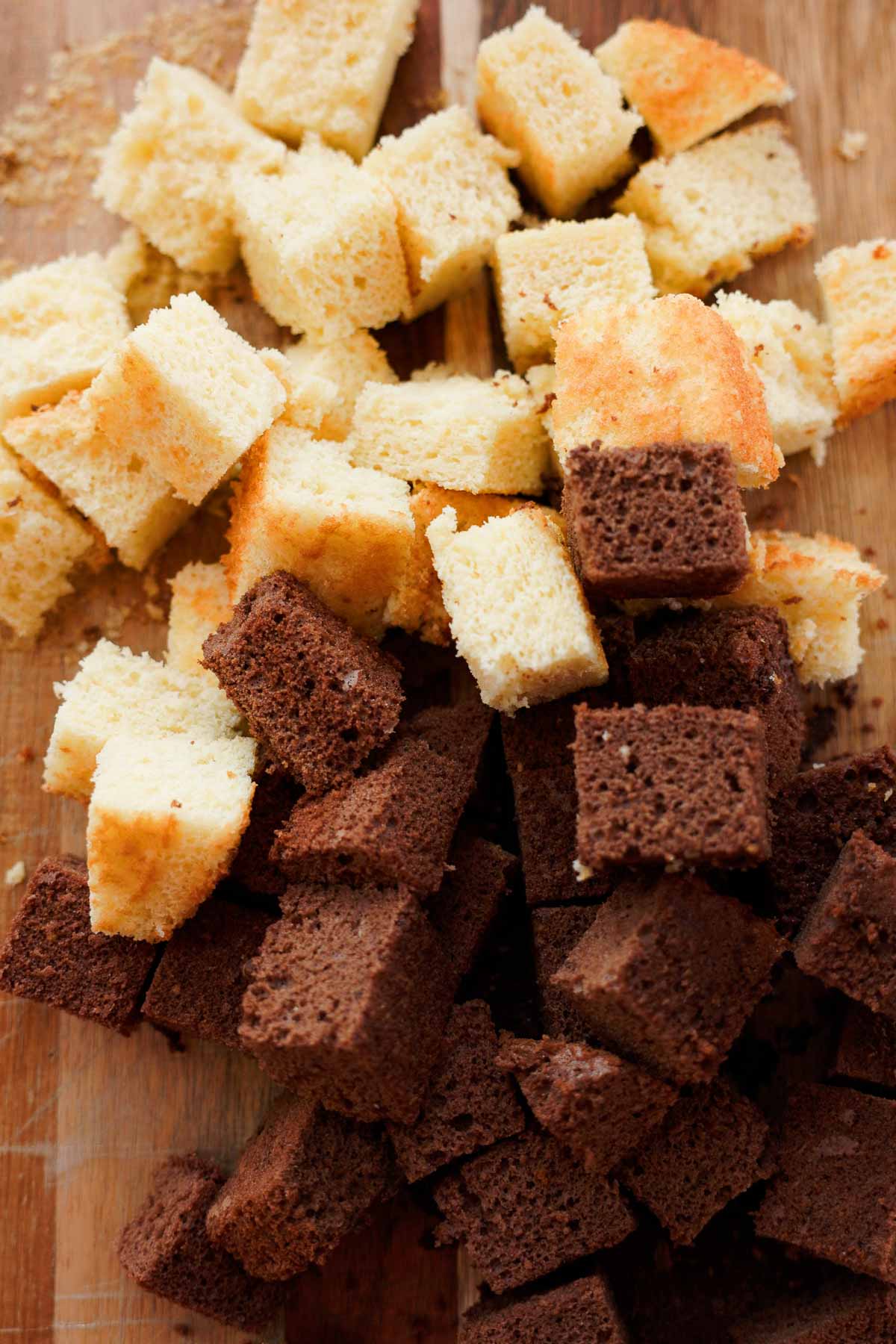 chocolate and vanilla sponge cake cut into cubes on cutting board