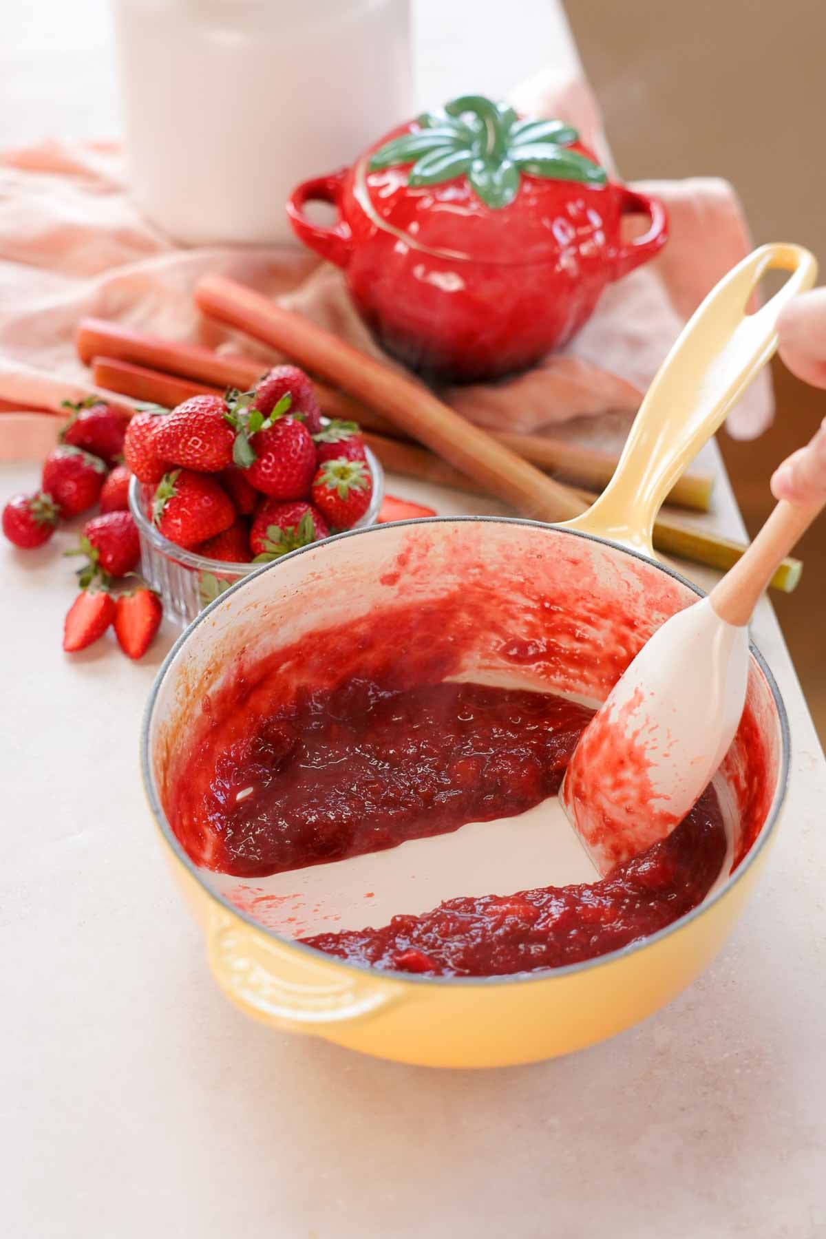stirring rhubarb sauce with spatula in saucepan