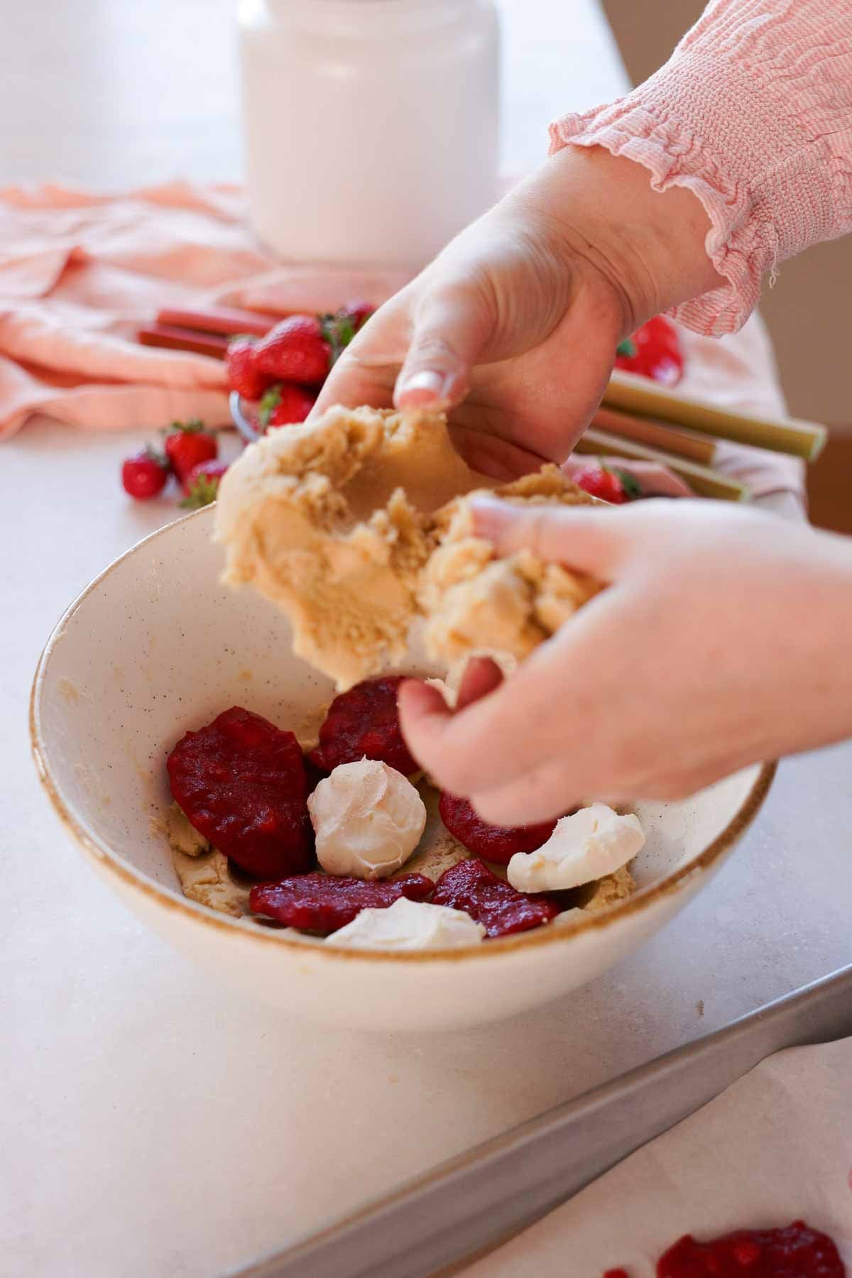 layering cookie dough with rhubarb and cheesecake filling