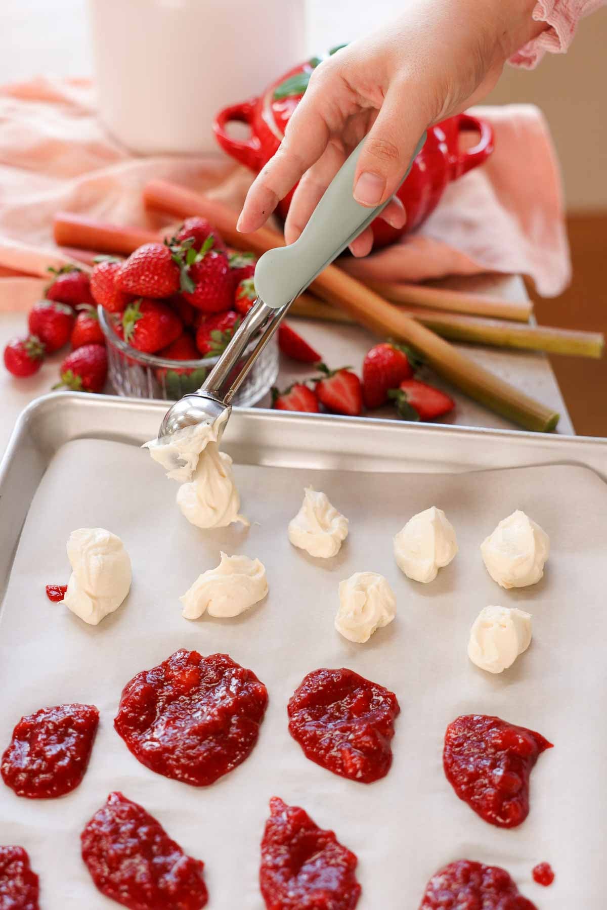 scooping dollops of cream cheese mixture onto parchment paper