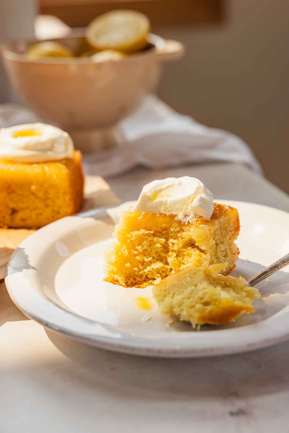 slice of upside down lemon cake on plate with bite taken out of it