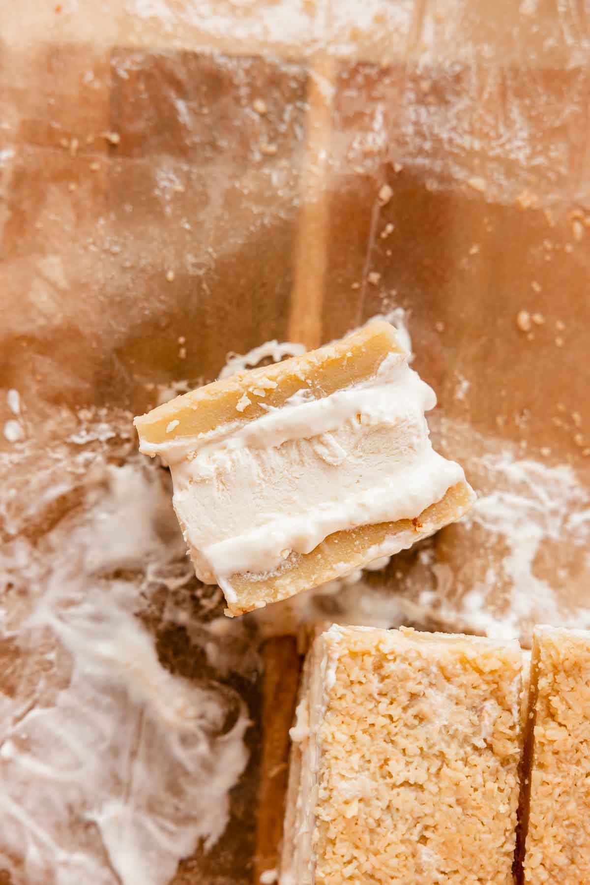 butter mochi ice cream sandwich with toasted coconut ice cream on parchment paper