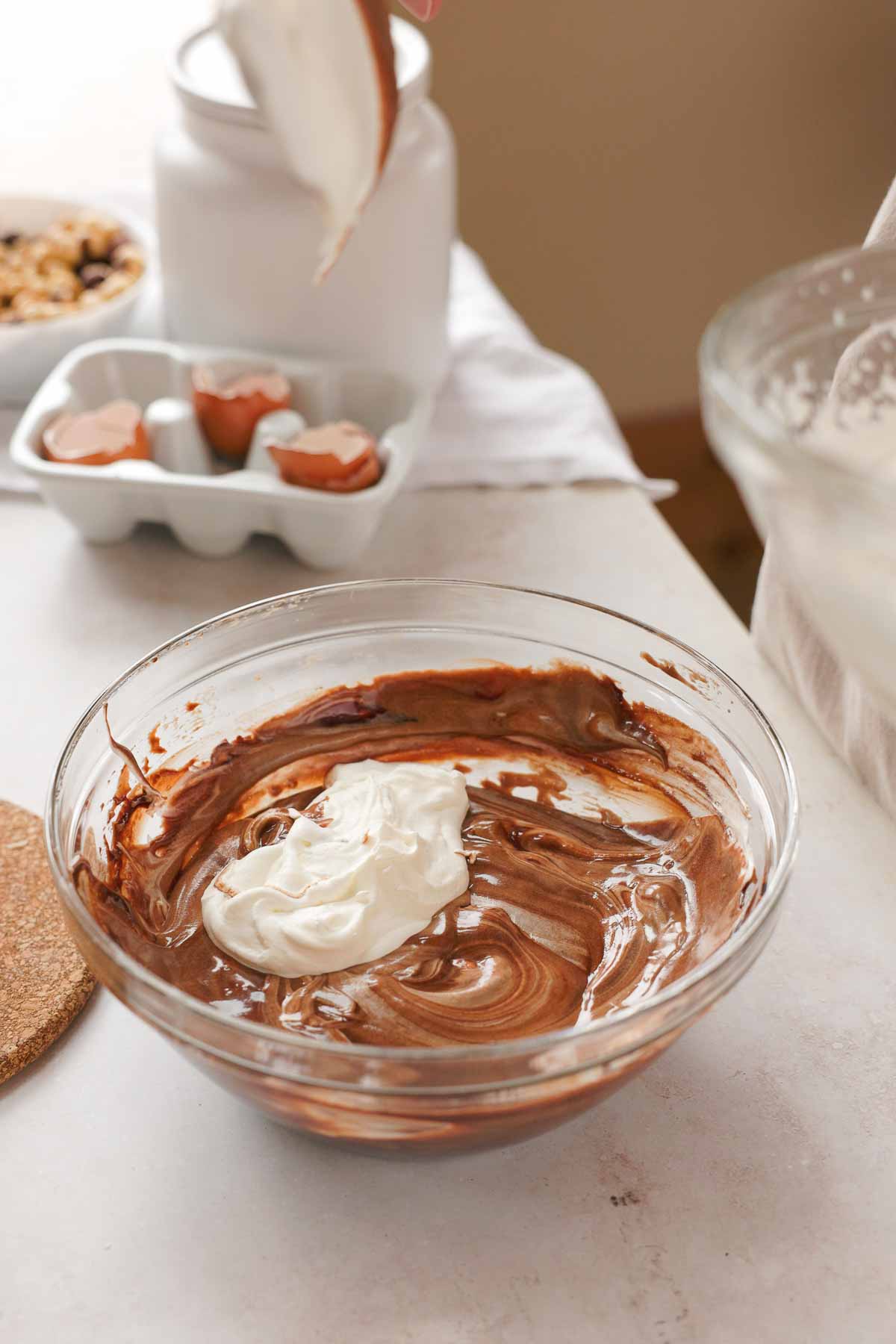 gradually folding whipped cream and egg whites into chocolate mixture