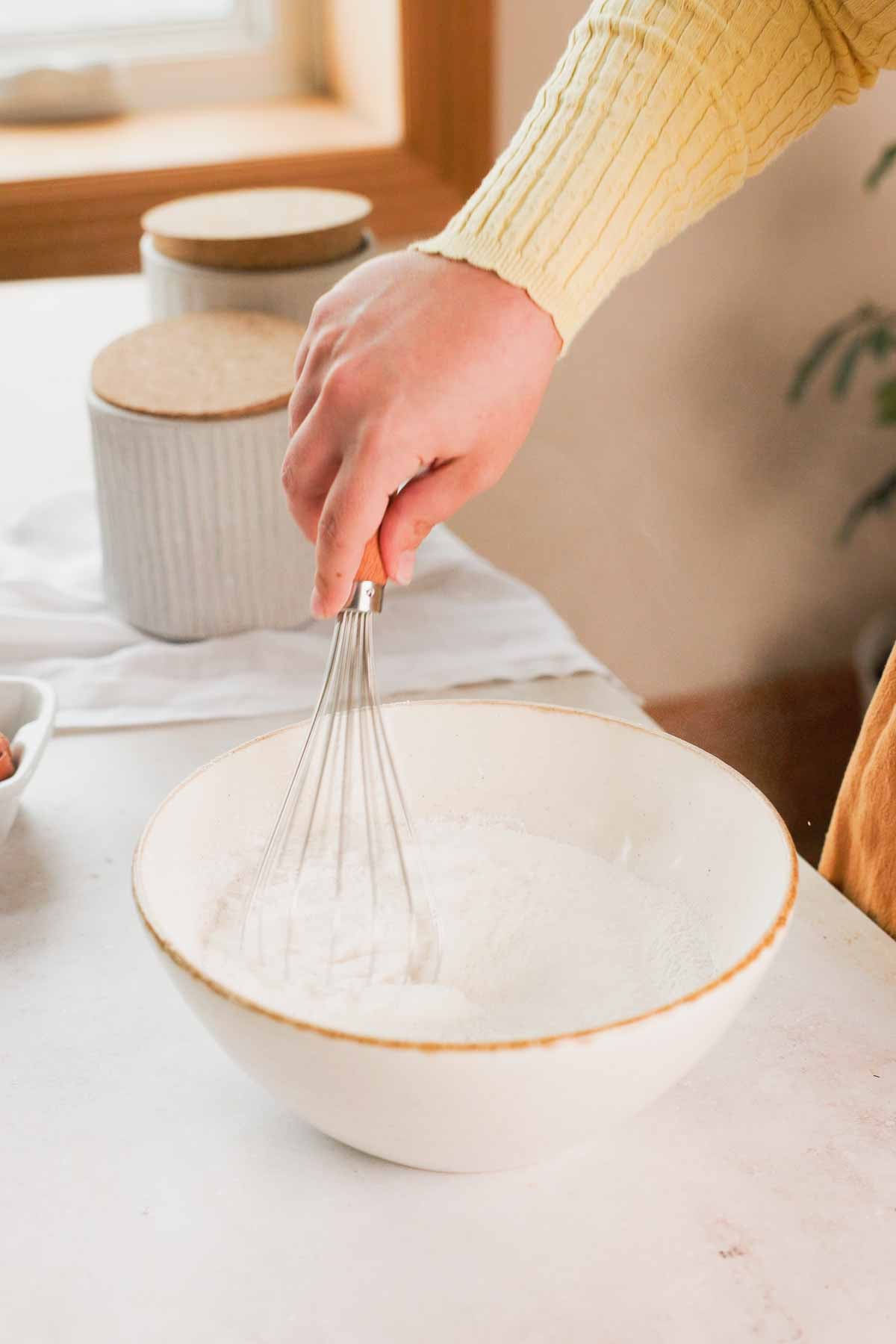 whisking dry ingredients for butter mochi in a large glass bowl