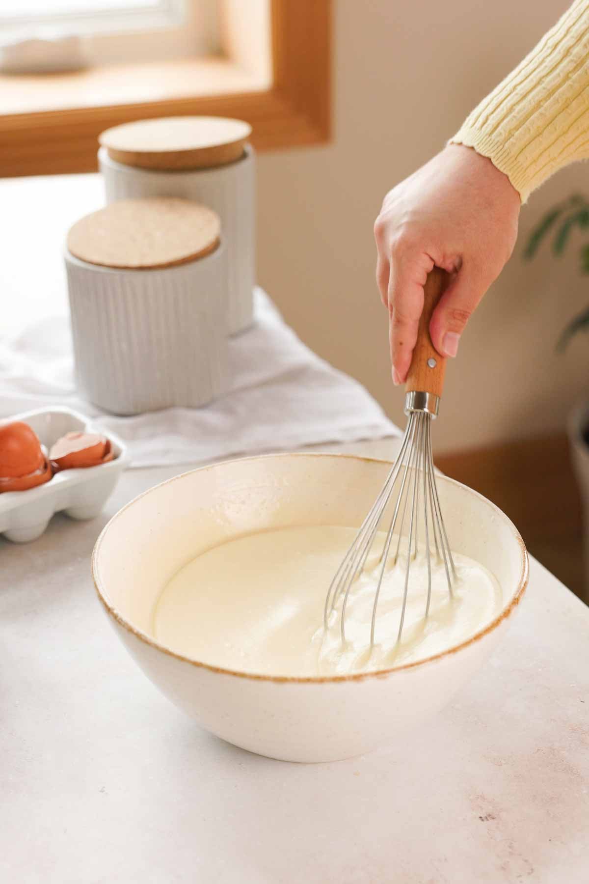 whisking butter mochi batter in a large bowl