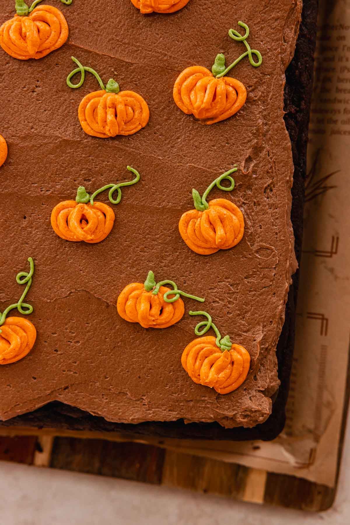 chocolate cake with chocolate frosting with small piped pumpkins on top
