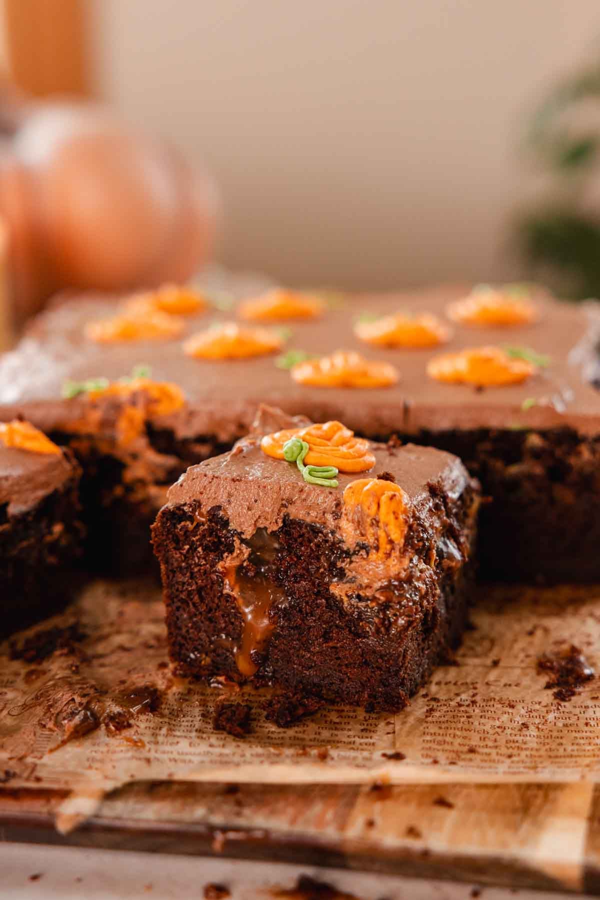 slice of gooey chocolate pumpkin caramel cake on parchment paper