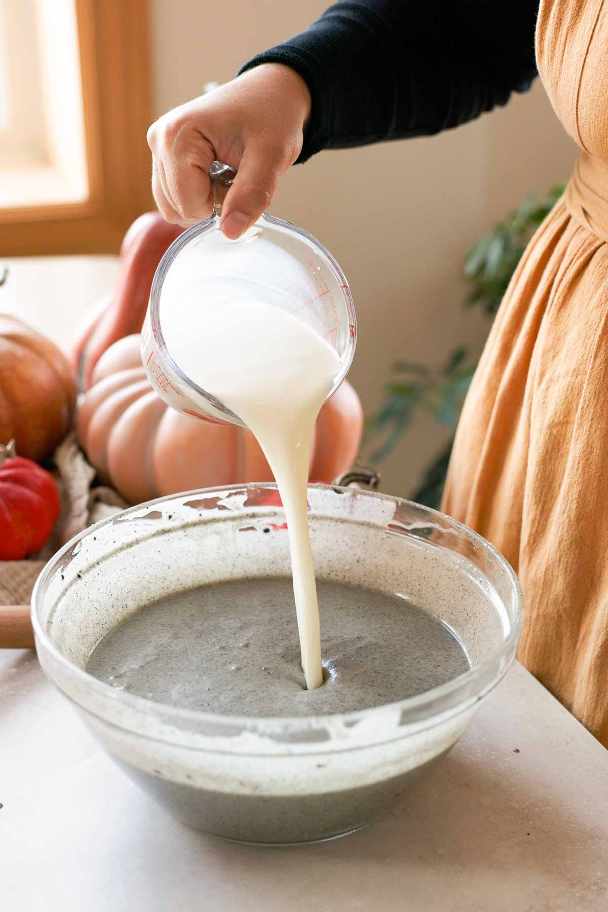 pouring milk into black sesame butter mochi batter