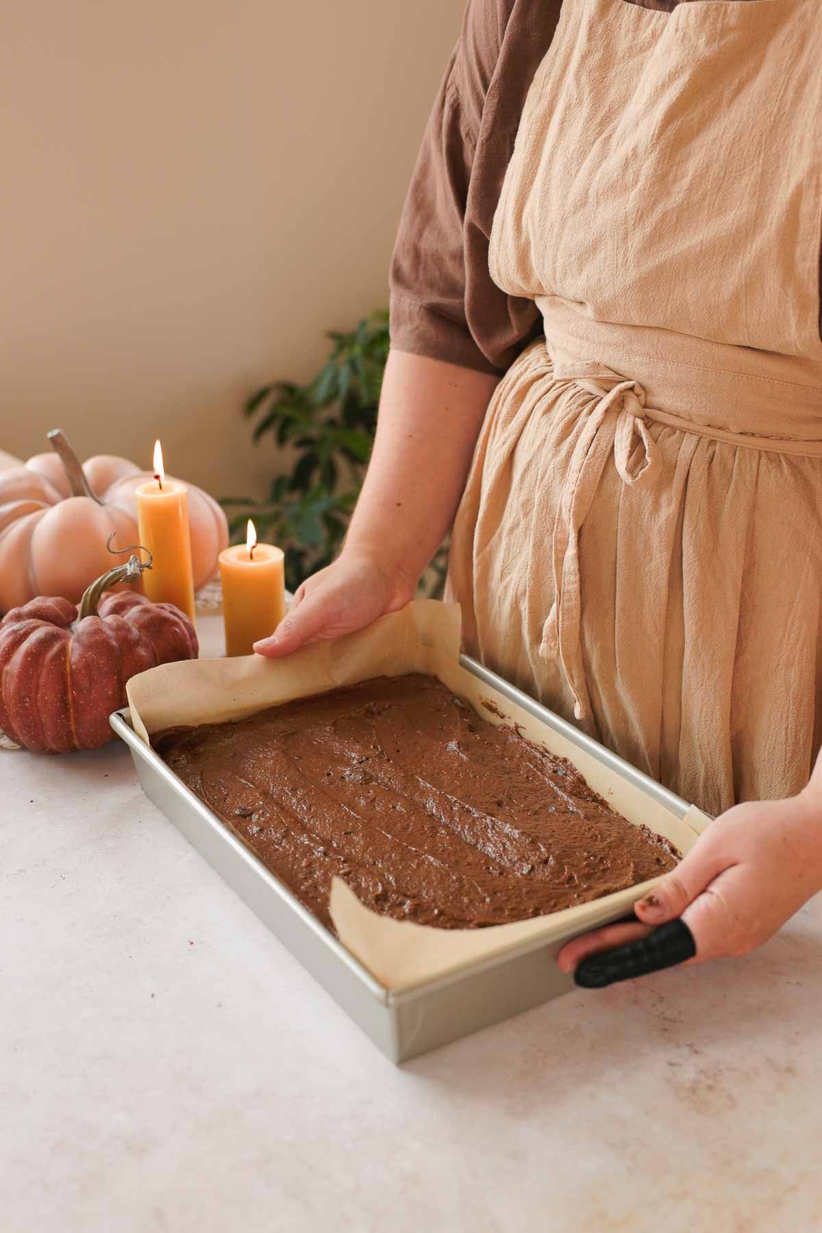 rectangle cake pan lined with parchment paper and filled with chocolate pumpkin batter
