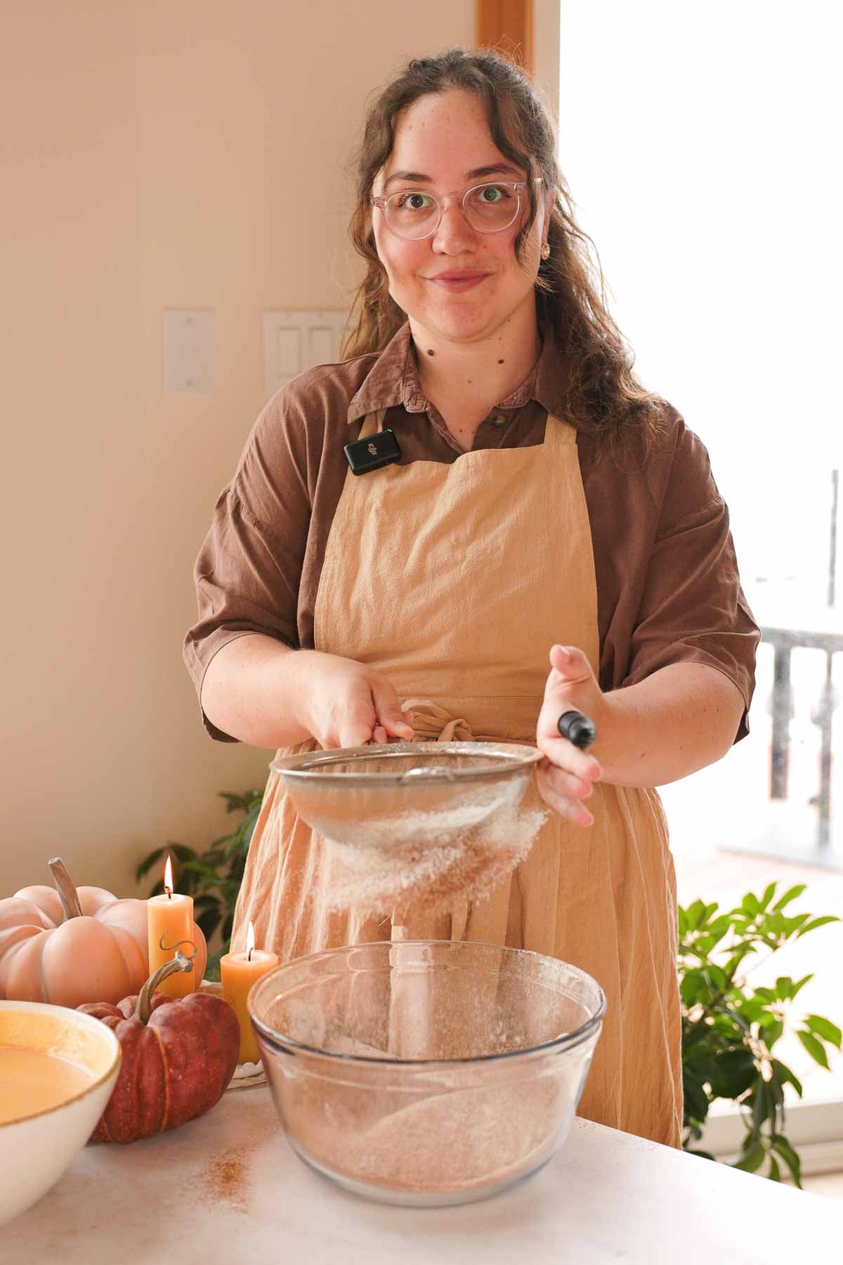 sifting dry pumpkin cake ingredients into large glass bowl